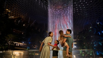 Familie mit zwei Kindern bewundert den HSBC Rain Vortex im Jewel Changi