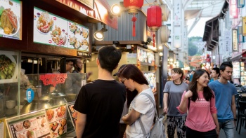 People looking at a menu at Chinatown Food Street stall