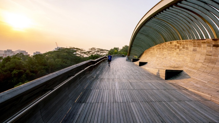A boy walking on the Henderson Waves Bridge during the golden hour