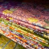 A neatly stacked variety of batik fabric from Royal Fabrics