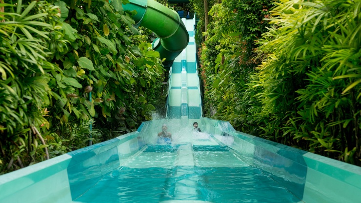 Kids playing in the water slide in the Adventure Cove Waterpark at Resorts World™ Sentosa