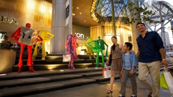 一家人经过爱雍·乌节购物中心 (ION Orchard) 外的 Urban people 雕像