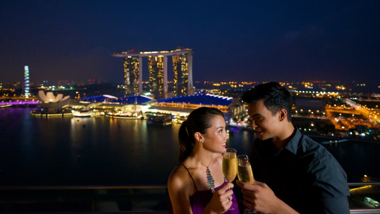 Couple with glasses of champagne with Marina Bay Sands and Art Science Museum in background