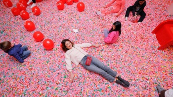 ผู้หญิงนอนอยู่ใน Sprinkle Pool ของ Museum of Ice Cream 