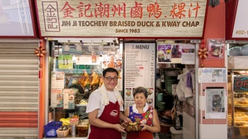 Các chủ quán của Jin Ji Teochew Braised Duck tạo dáng chụp hình trước quầy hàng của họ