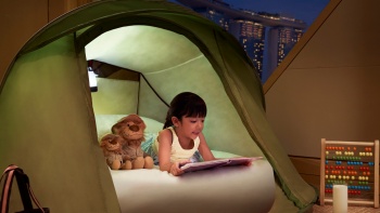 Bé gái trong lều đọc sách ở The Ritz-Carlton Millenia Singapore