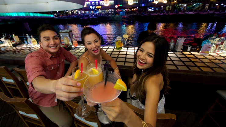 3 friends enjoying drinks at Clarke Quay